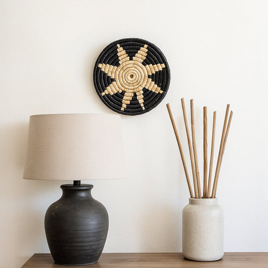 Starburst metal wall decor in bold contrasting finish placed on clean shelf bringing sculptural depth and statement design to minimalist interior setup.