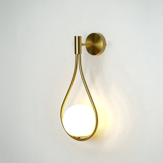 Modern gold metal wall light with warm ambient glow for stylish bedroom and luxury decor spaces.