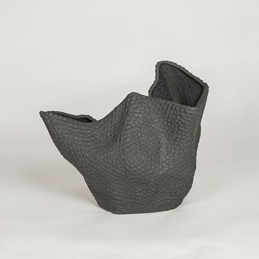 Organic textured black ceramic vase with unique sculptural shape for modern home shelf and tabletop decor style.