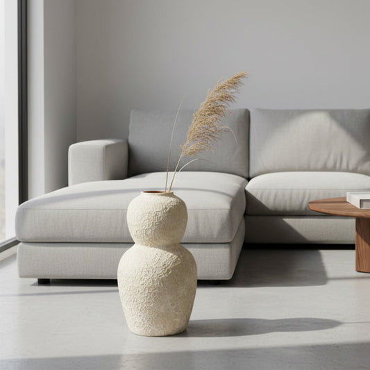 White textured ceramic vase lifestyle image beside modern sofa for cozy contemporary interior table decor.