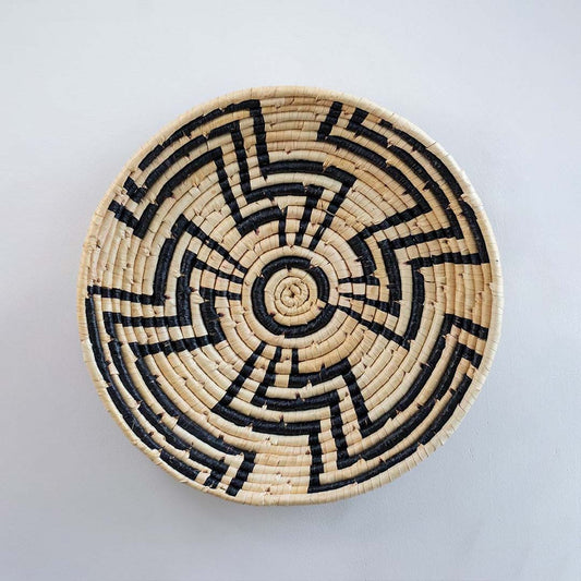 Natural and black handcrafted woven wall basket with geometric pattern for elegant wall decor and home styling.