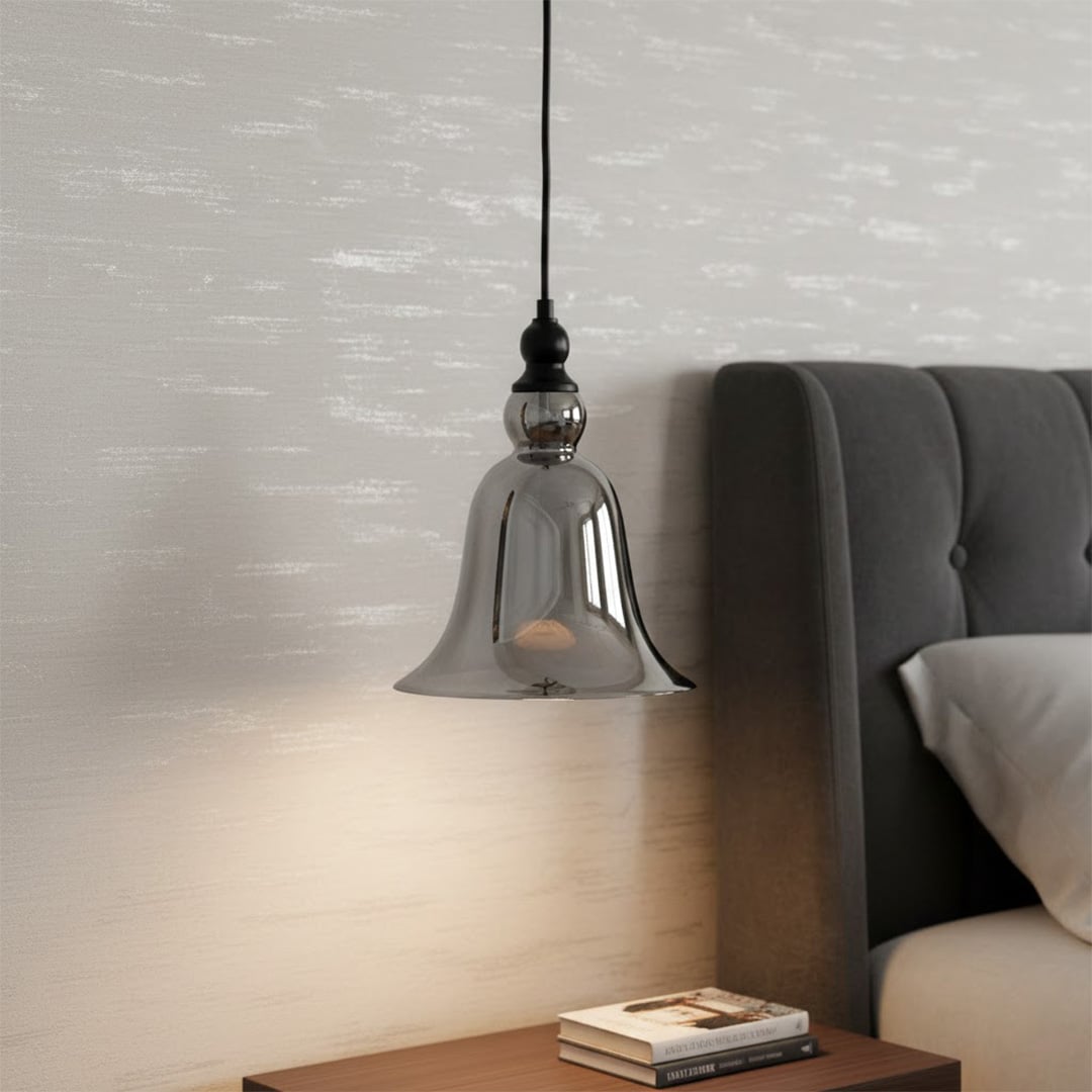 Smoky brown glass pendant light illuminating bedside decor with warm ambiance and contemporary appeal.