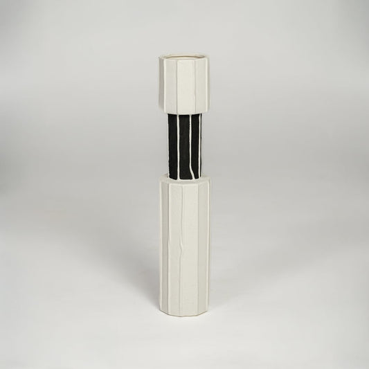 White and black metal decorative candle holder with sleek cylindrical form isolated on white background for contemporary home decor use.