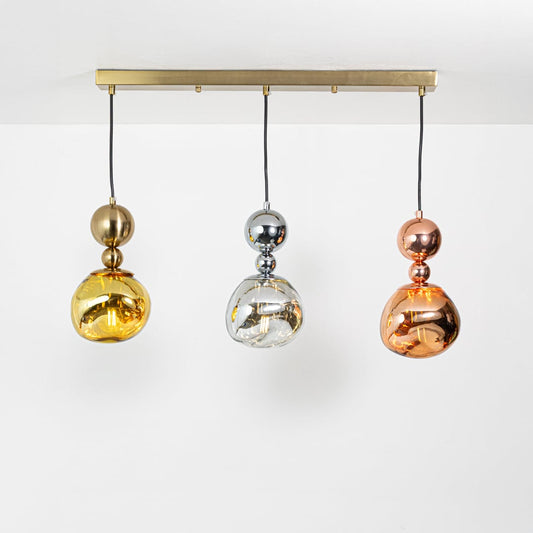 Gold chrome and copper pendant lights glowing softly against a white background creating warm ambient illumination and adding elegant metallic charm to interior decor.