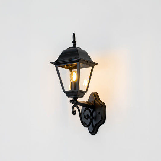 Black metal outdoor lantern wall light on white background with decorative mount for elegant exterior decor.
