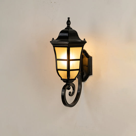 Classic black metal outdoor wall lantern on white background with frosted glass paneled shade and elegant scroll arm detail.