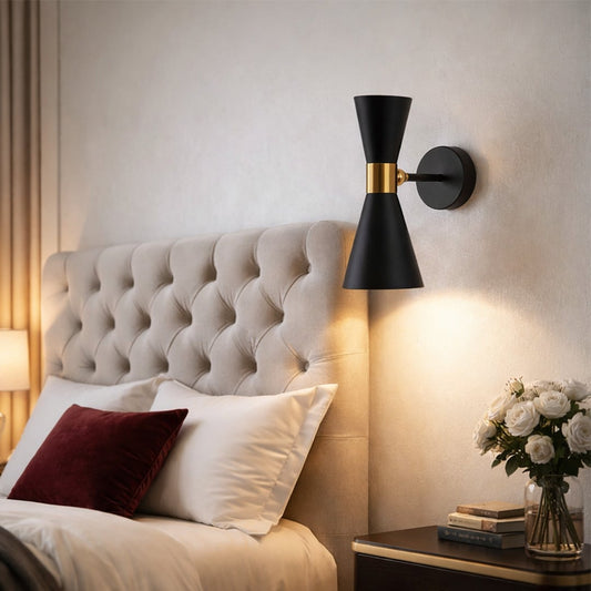 Elegant black metal spotlight wall light enhancing cozy bedroom ambiance with warm modern lighting.