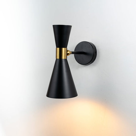 Black and gold modern wall sconce with its light on displayed against a clean white background highlighting its sleek conical double shade design.