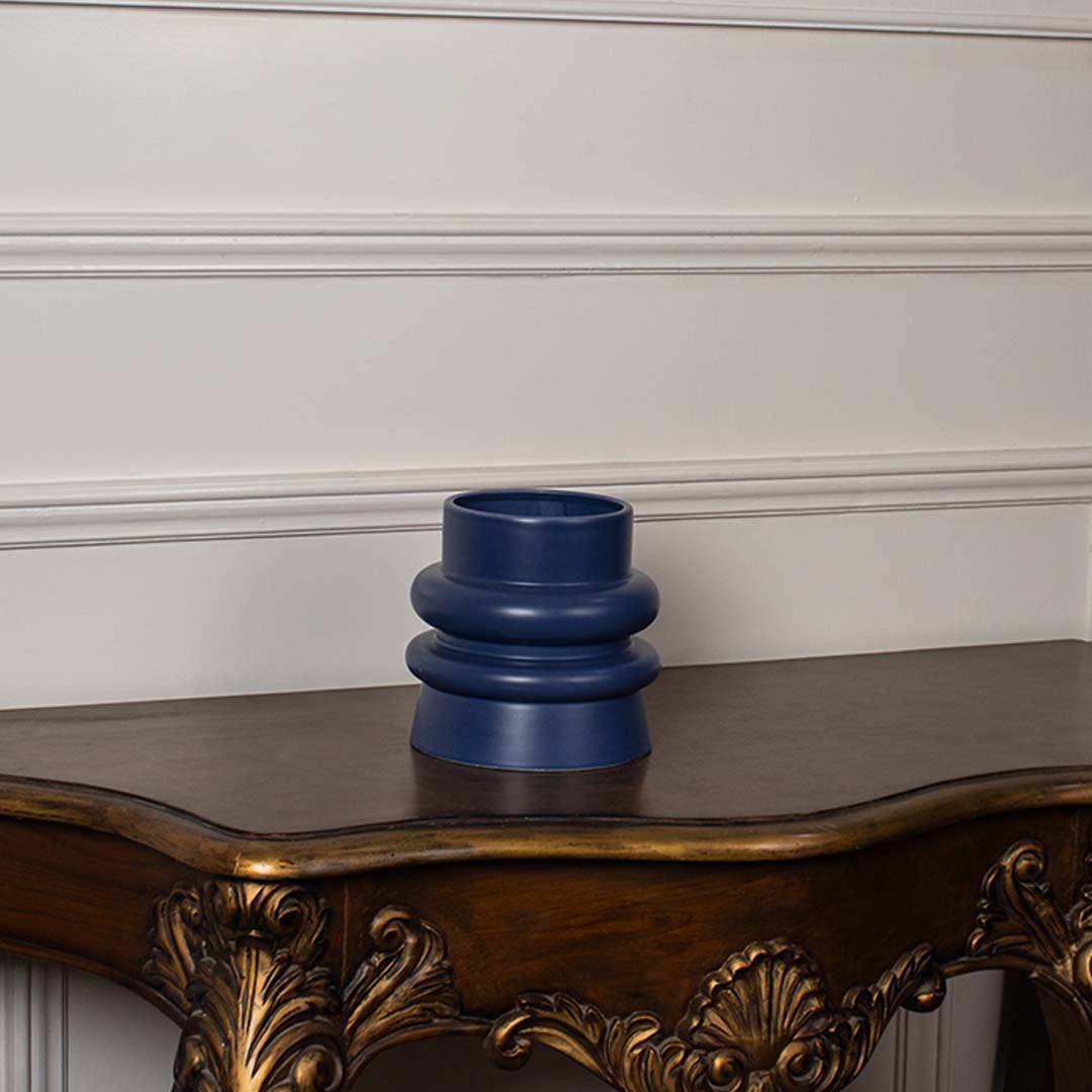 Deep blue ceramic vase with sculpted round layers shown on a clean white background highlighting its smooth matte finish and modern shape.