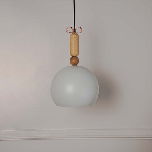 White dome pendant light with wooden holder and hanging cord placed against neutral wall background showcasing clean minimal lighting decor aesthetic.