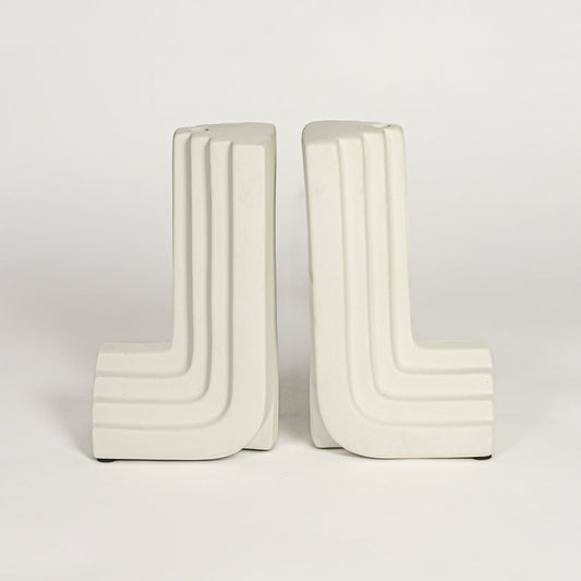 White ceramic modern bookends on white background minimal sculptural decor accessory for shelf or office styling.
