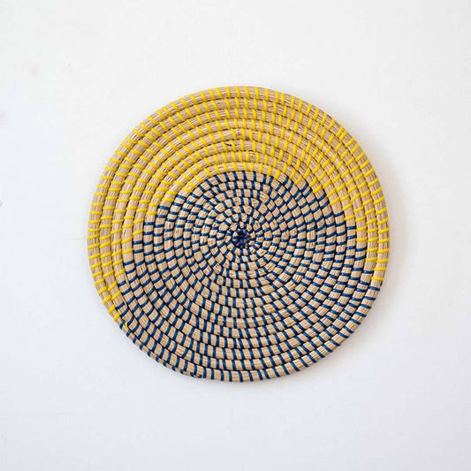Handwoven seagrass round wall basket decor in yellow and charcoal with modern woven pattern displayed on white background.