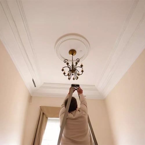 Chandelier installation in modern hallway with elegant lighting setup and professional hanging decor guidance.