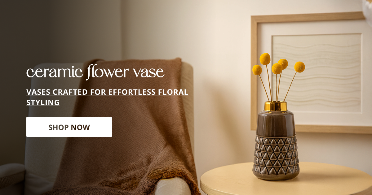 Ceramic flower vase displayed with dried stems on side table enhancing warm aesthetic interior styling.
