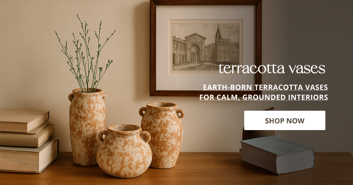 Terracotta vases set on wooden table with books and framed wall art rustic earthy home decor styling