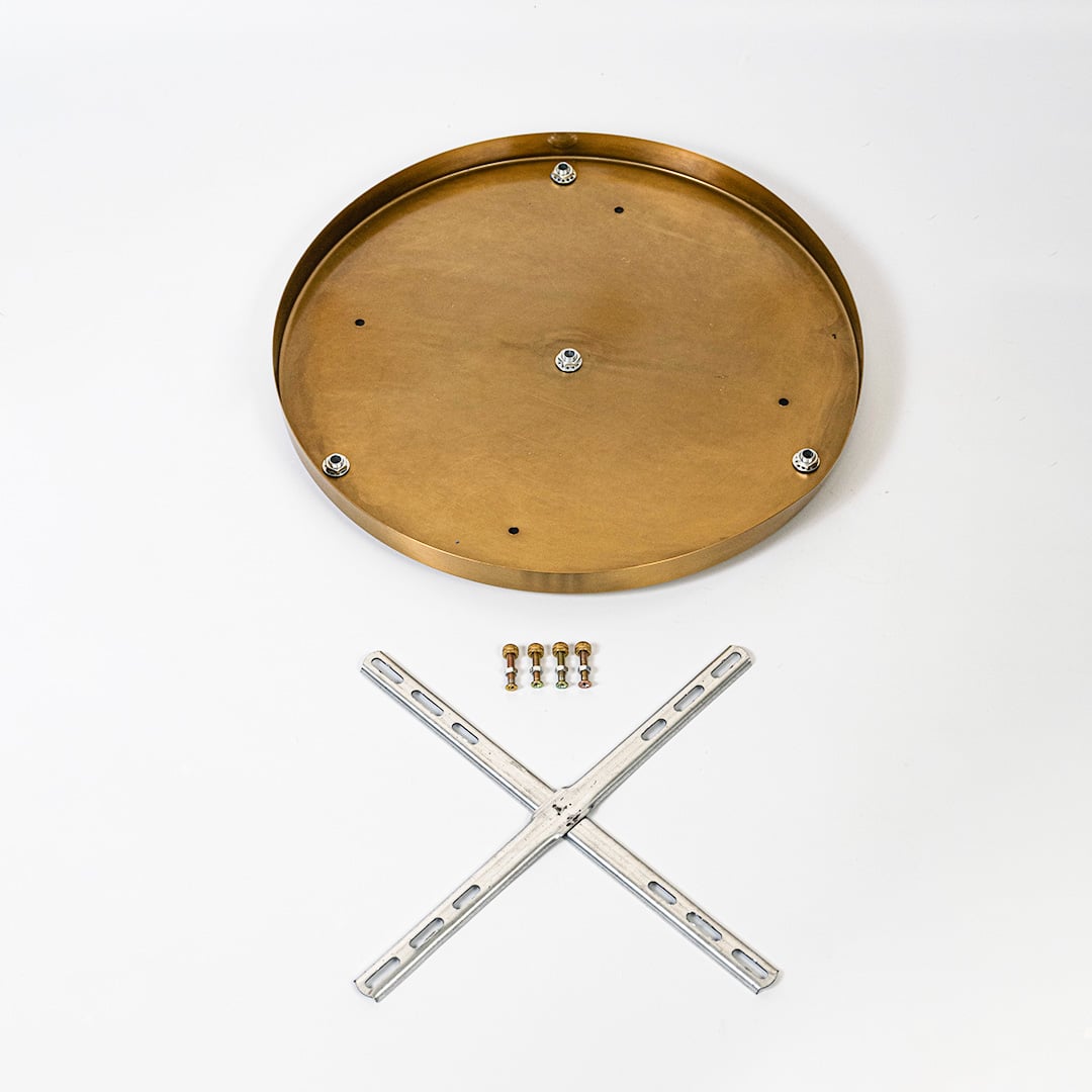 Round metal ceiling plate in warm gold finish shown with cross mounting bracket screws and hardware laid out on white background.