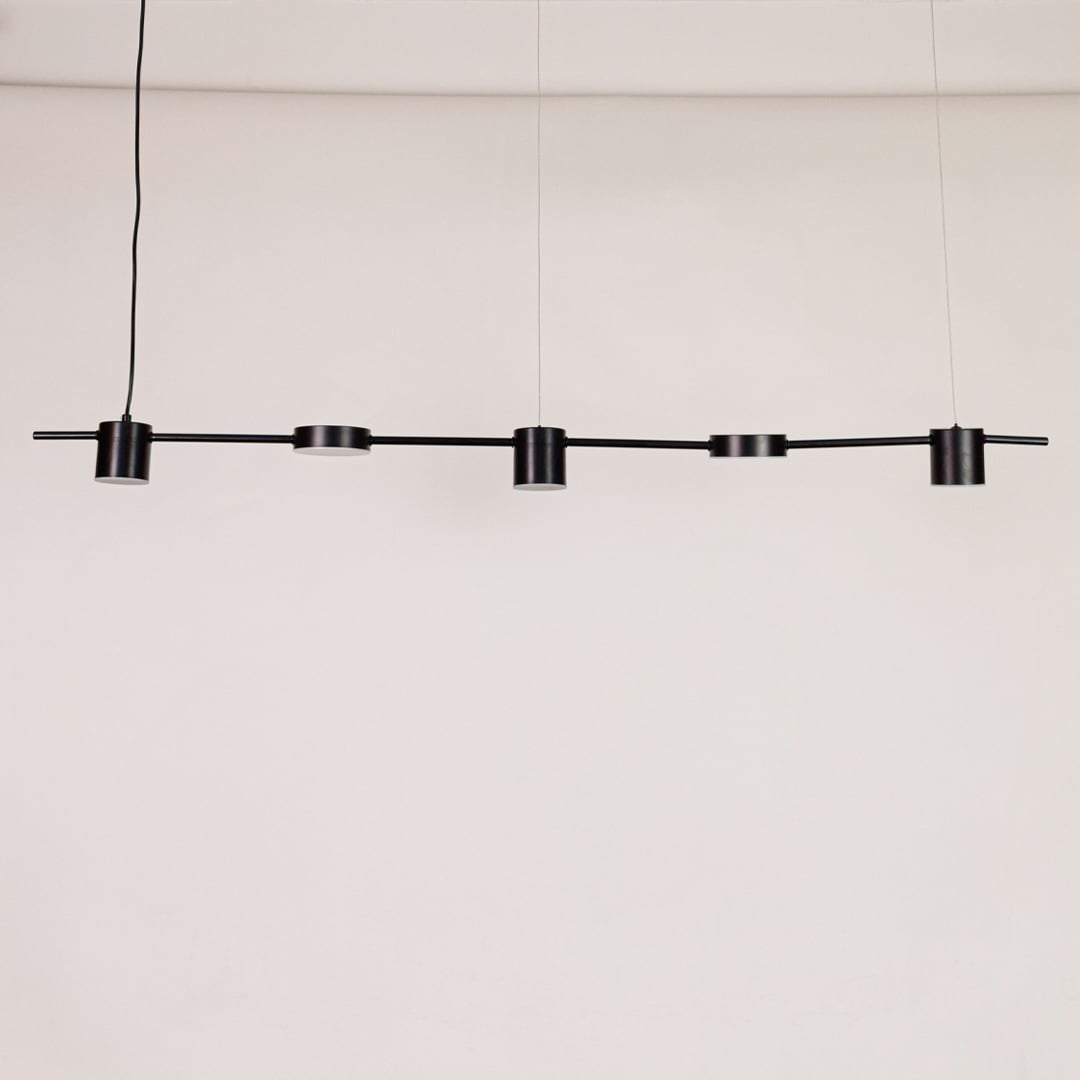 Black linear pendant light displayed unlit on white background with multiple adjustable heads for modern dining or kitchen lighting.