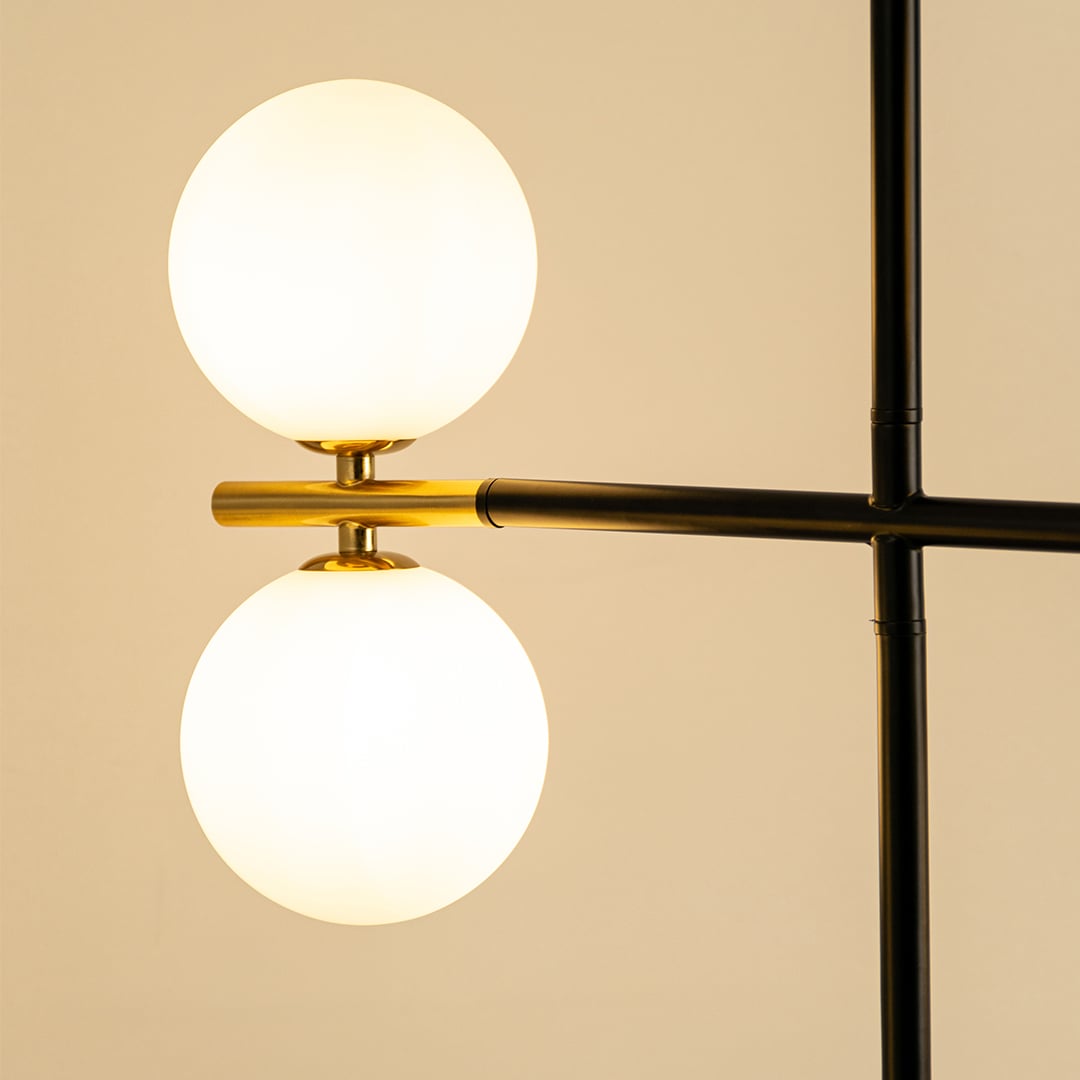 Frosted glass globe chandelier with gold accents and black metal frame showcasing elegant modern lighting craftsmanship.
