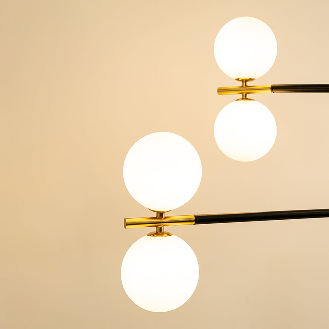 Frosted glass globe shades with gold metal detailing highlighting premium materials and contemporary chandelier design.