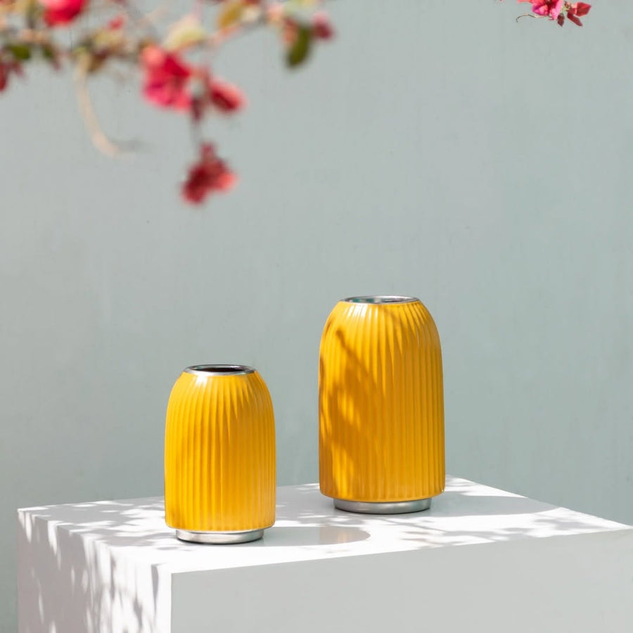 A bright yellow ribbed vase displayed in a clean minimal setting adding a vibrant modern accent to contemporary home decor styling.