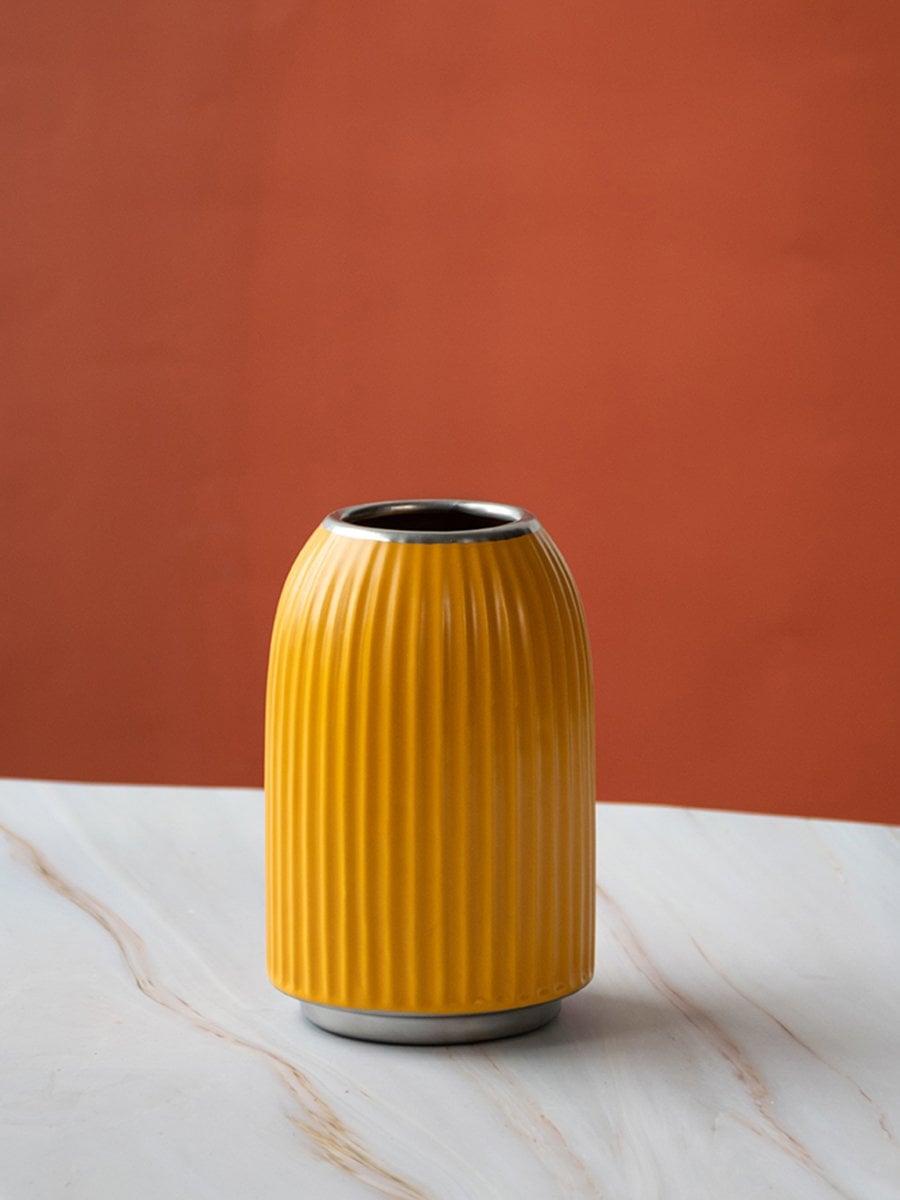 A yellow ribbed decorative vase shown on a plain white background presenting a clean simple and modern product display for catalog use.