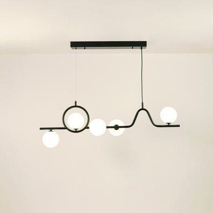 Black metal chandelier with frosted glass globe shades creating warm ambient lighting for modern dining room interiors.