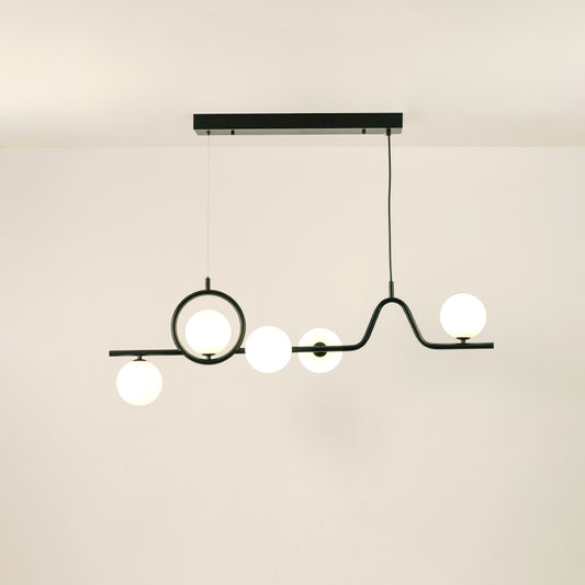 Black metal chandelier with frosted glass globe shades creating warm ambient lighting for modern dining room interiors.