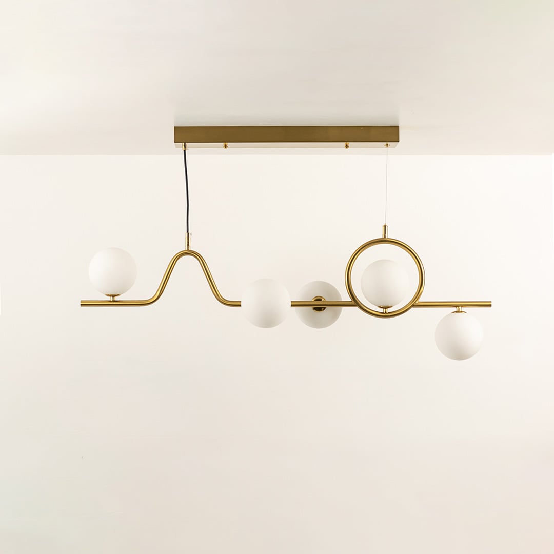 Gold chandelier with circular accent and white globe bulbs in a front view against a plain background with lights on perfect for artistic lighting décor.
