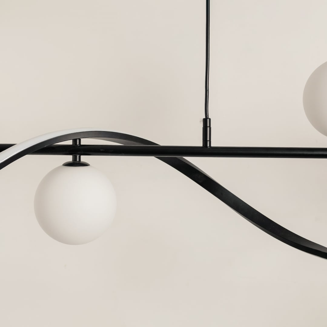 Detailed view of black wave chandelier showing smooth curves and frosted white globes for stylish interior lighting.