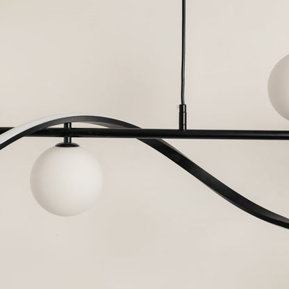 Detailed view of black wave chandelier showing smooth curves and frosted white globes for stylish interior lighting.