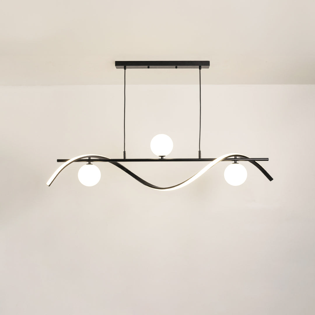 Black metal chandelier with frosted glass globe shades and curved frame creating modern ambient ceiling lighting indoors.