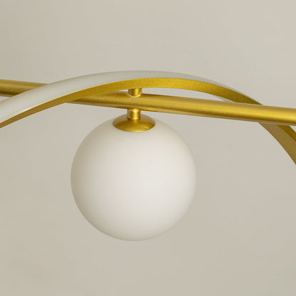 Detailed closeup of gold wave chandelier highlighting curved metal design and soft matte white globes for modern interiors.