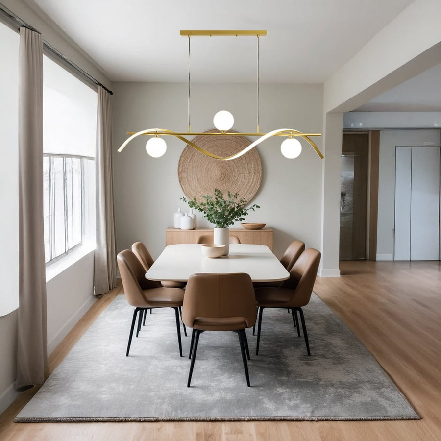 Modern gold metal wave chandelier with white globes styled in a warm living room setting for elegant ceiling lighting decor.