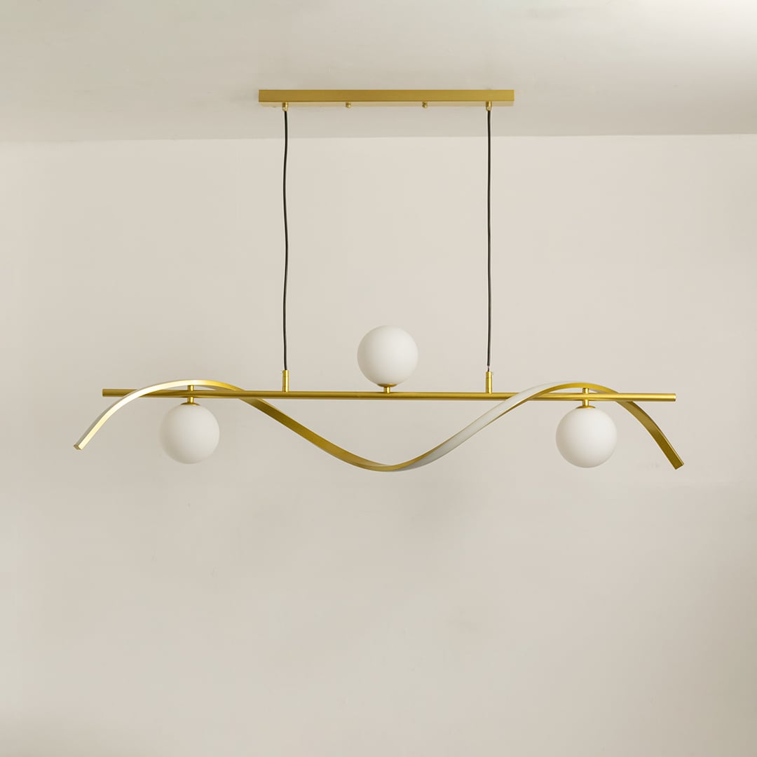 Gold metal wave chandelier with white globes displayed on a bright white background with lights switched off.