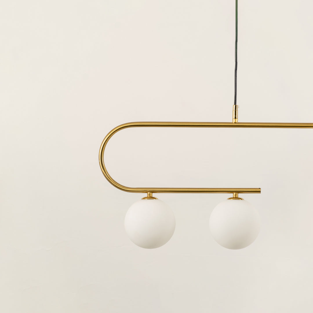 Gold metal chandelier with frosted glass globe shades highlighting premium craftsmanship and contemporary ceiling lighting.