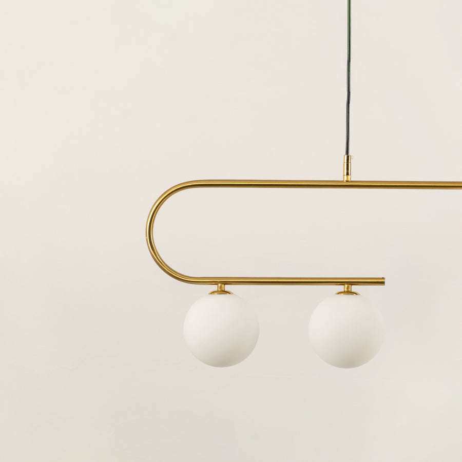 Gold metal chandelier with frosted glass globe shades highlighting premium craftsmanship and contemporary ceiling lighting.