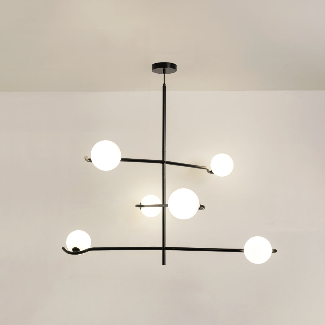 Black metal chandelier with frosted glass globe shades and geometric frame offering contemporary ceiling lighting design.