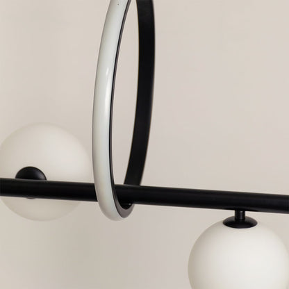 Detailed closeup of black metal chandelier showing round frosted spheres curved frame and modern ring accent.