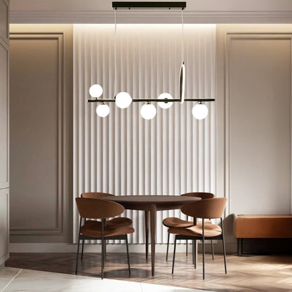 Black metal chandelier with frosted glass globes styled in a modern interior adding warm elegant ambient lighting to the room.