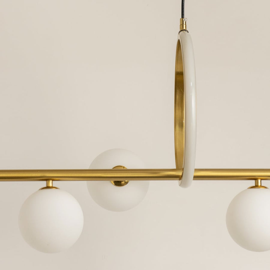 Detailed closeup of gold metal chandelier showing ring detail curved frame and frosted globes with elegant finish.