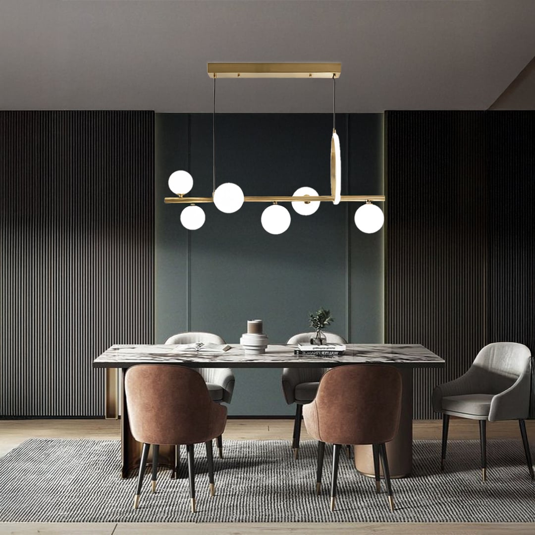 Gold metal chandelier with frosted glass globes styled in a modern interior adding warm elegant ambient lighting to the space.