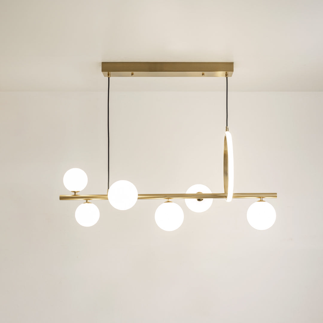 Gold metal chandelier with frosted glass globe shades and vertical LED accent creating elegant modern ceiling lighting.