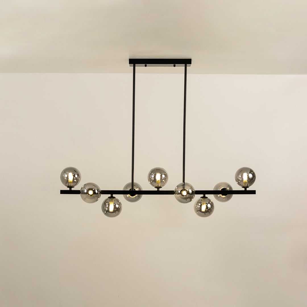 Smoked glass globe chandelier with illuminated glass shades creating sophisticated ambient lighting for modern interiors.