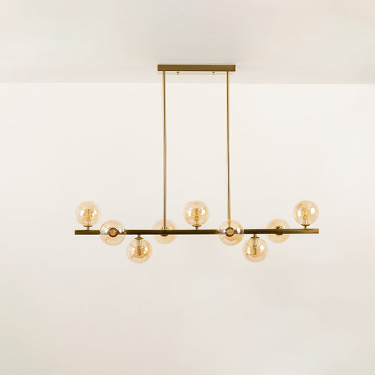 Gold multi arm chandelier with round globe bulbs in a front view against a plain white background with lights on perfect for luxury ceiling décor.