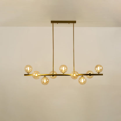 Gold multi arm chandelier with globe bulbs in a front view against a plain background with lights on ideal for luxury décor and premium home lighting.
