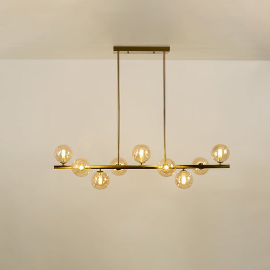 Gold multi arm chandelier with globe bulbs in a front view against a plain background with lights on ideal for luxury décor and premium home lighting.