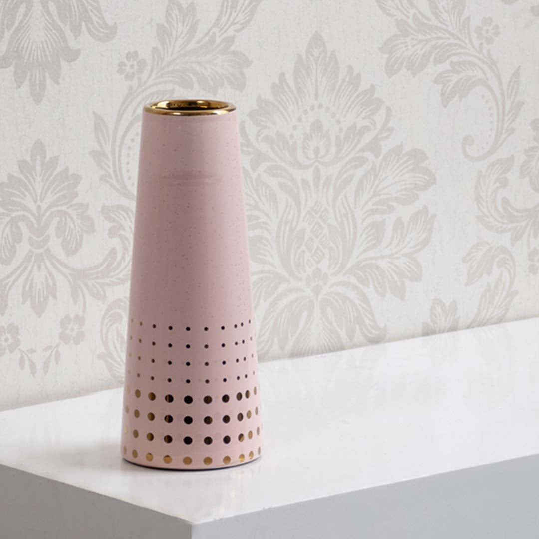 Pink ceramic vase with gold rim and perforated detailing displayed on a clean white background for a modern minimal decorative look.