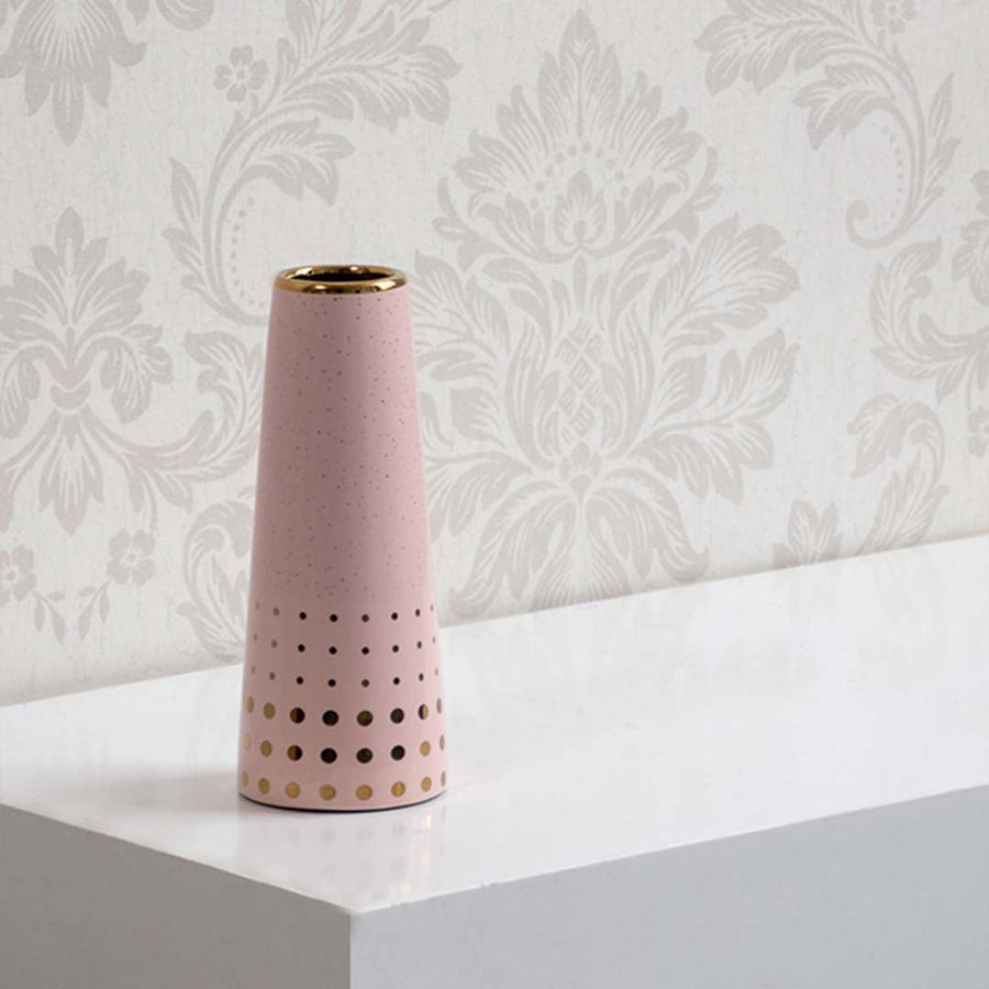 Modern pink ceramic vase featuring gold detailing and perforated design shown on a bright background for clean contemporary home decor.