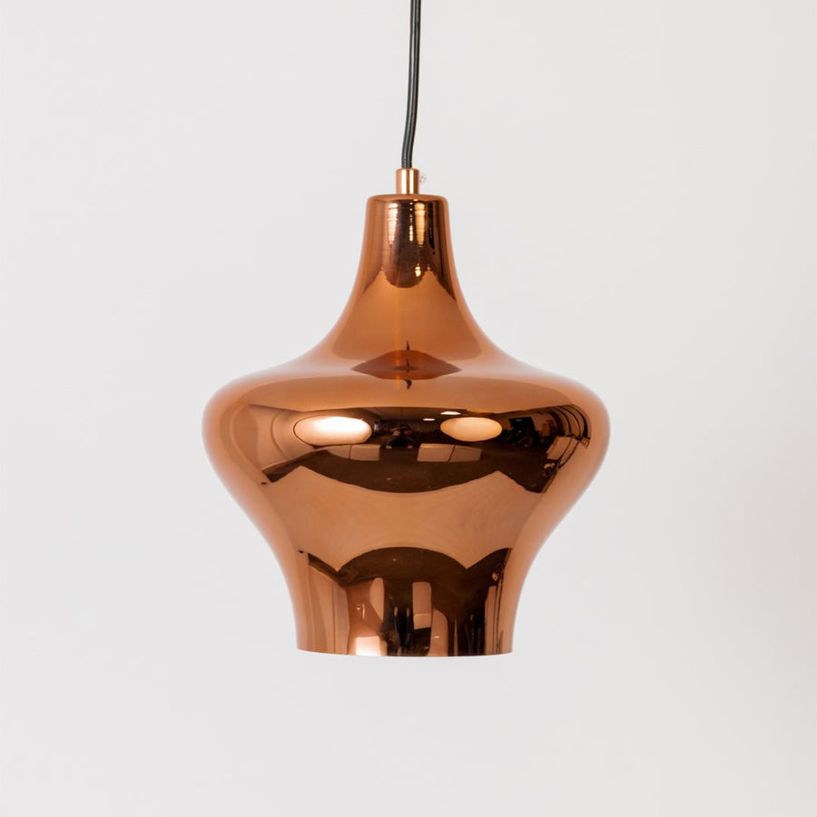 Copper metal pendant light illuminated to display elegant decorative ceiling lighting with sophisticated modern appeal.