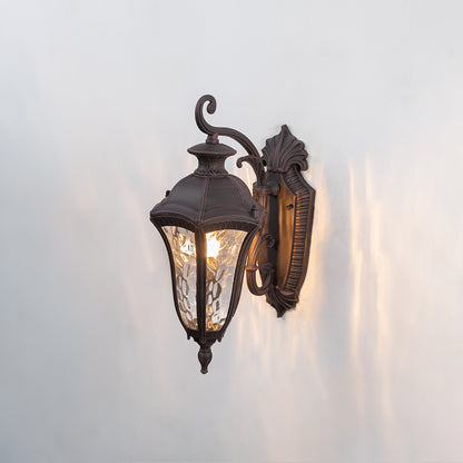 Vintage black metal outdoor wall light with textured glass shade for classic exterior entryway decor.